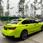 Rear three-quarter shot BMW 3 Series wrapped with MOZX Gloss Neon Lime reflective glossy TPU car film