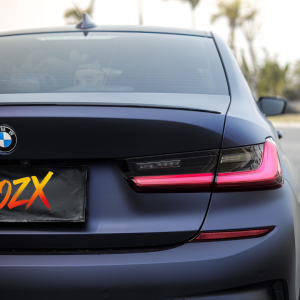Front headlight and fender close-up BMW 3 Series with MOZX Matte Midnight Purple matte TPU wrap, wheel arch fitting detail