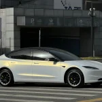Full side profile Tesla Model 3 with MOZX Easy White Iridescent Gold PET vinyl wrap, urban road outdoor daylight shot golden color shift