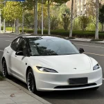 Front three-quarter full body Tesla Model 3 MOZX White Iridescent Gold PET vinyl wrap, roadside residential daylight full car shot