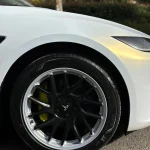 Front wheel fender close-up Tesla Model 3 MOZX White Iridescent Gold PET wrap, golden iridescent reflection on wheel arch panel