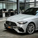 Close-up front fascia of Mercedes wrapped in MOZX Smart Nardo Grey PET wrap, seamless contour wrapping on AMG splitter & grille