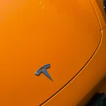 Three-quarter front view Tesla Model Y wrapped MOZX Easy McLaren Orange glossy PET vinyl wrap, bright sport racing orange EV showcase