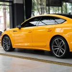 Full rear side two-door view Audi RS wrapped MOZX Smart McLaren Orange glossy PET vinyl wrap, uniform orange color across entire body