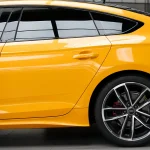 Macro close-up Audi RS rear door panel wrapped MOZX Smart McLaren Orange PET wrap, grain-free mirror smooth high gloss texture