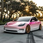 Tesla Model 3 pink-white pearlescent gradient wrap, gold wheels, sunset