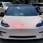 Tesla Model 3 front view wrapped with MOZX Smart White Iridescent Red PET Car Wrap, white chameleon red shift vinyl film