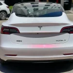 Rear shot Tesla Model 3 covered by MOZX Smart White Iridescent Red PET chameleon vinyl wrap