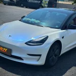 Tesla front view MOZX Easy white iridescent blue PET vinyl wrap outdoor sunlight