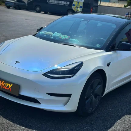 Tesla front view MOZX Easy white iridescent blue PET vinyl wrap outdoor sunlight