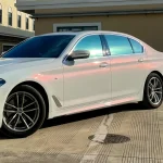 Full side front BMW 5 Series wrapped in MOZX Smart White Iridescent Red PET chameleon vinyl wrap