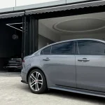 Side door close-up Jaguar XE wrapped MOZX Easy Bernina Grey gloss PET wrap, seamless wrapping on curved sedan body lines