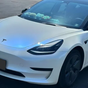 Tesla hood close‑up MOZX Smart white iridescent blue PET car wrap sunlight shimmer