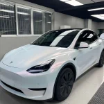 Front 45 degree Tesla Model Y covered by MOZX Elite White Iridescent Red chameleon TPU wrap
