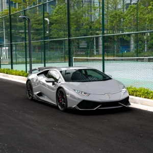 Full three-quarter shot Lamborghini Huracan wrapped MOZX Elite Nardo Grey glossy self-healing TPU PET wrap, tennis court outdoor supercar showcase